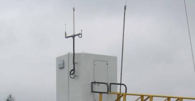 Local préfabiqué entouré d'eau. Puit et antennes visibles