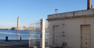 Port de Sète avec son phare (à gauche en arrière plan) et l'observatoire marégraphique (bâtiment à droite de l'image). Crédits SHOM, février 2011