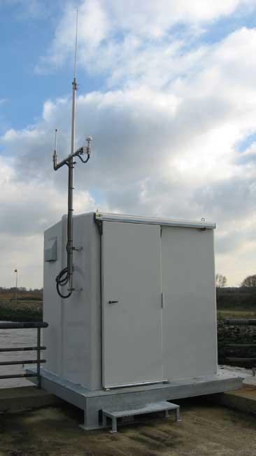 Local préfabiqué sur le bord du qué avec antenne de transmission