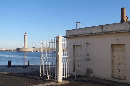 Port de Sète avec son phare (à gauche en arrière plan) et l'observatoire marégraphique (bâtiment à droite de l'image). Crédits SHOM, février 2011